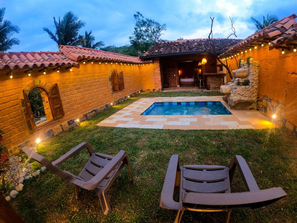 圣希尔Cabañas el Nopal的后院设有游泳池、两把椅子和房子