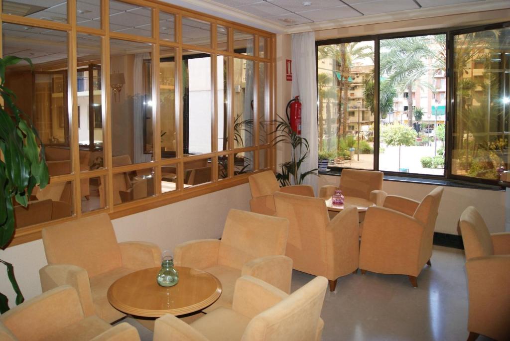 贝尼多姆罗莎贝尔酒店的配有桌椅和窗户的房间