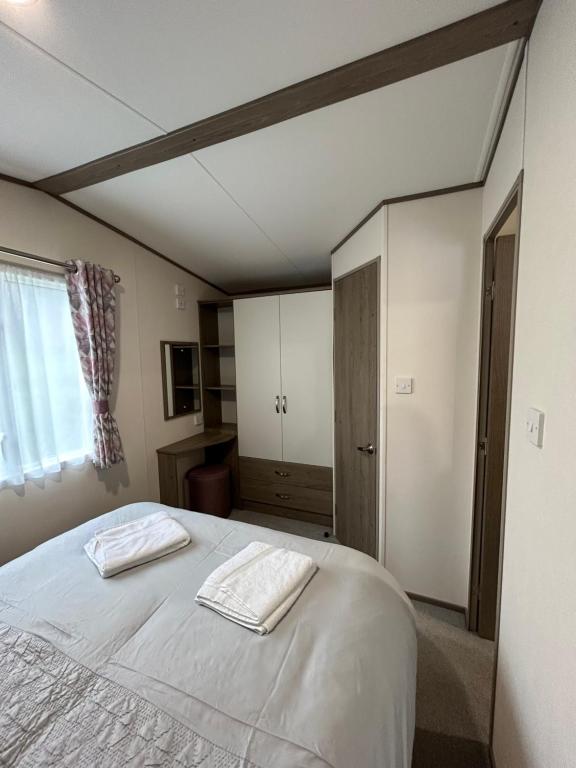 Cross InnDelightful 2 bedroom Caravan, Pencnwc, New Quay的一间卧室配有一张床,上面有两条毛巾