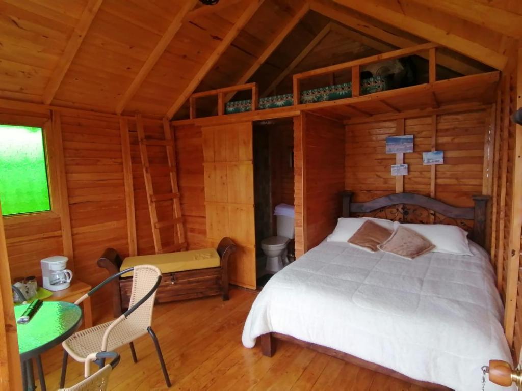 瓜塔维塔Cabañas Guatavita的小木屋内一间卧室,配有一张床