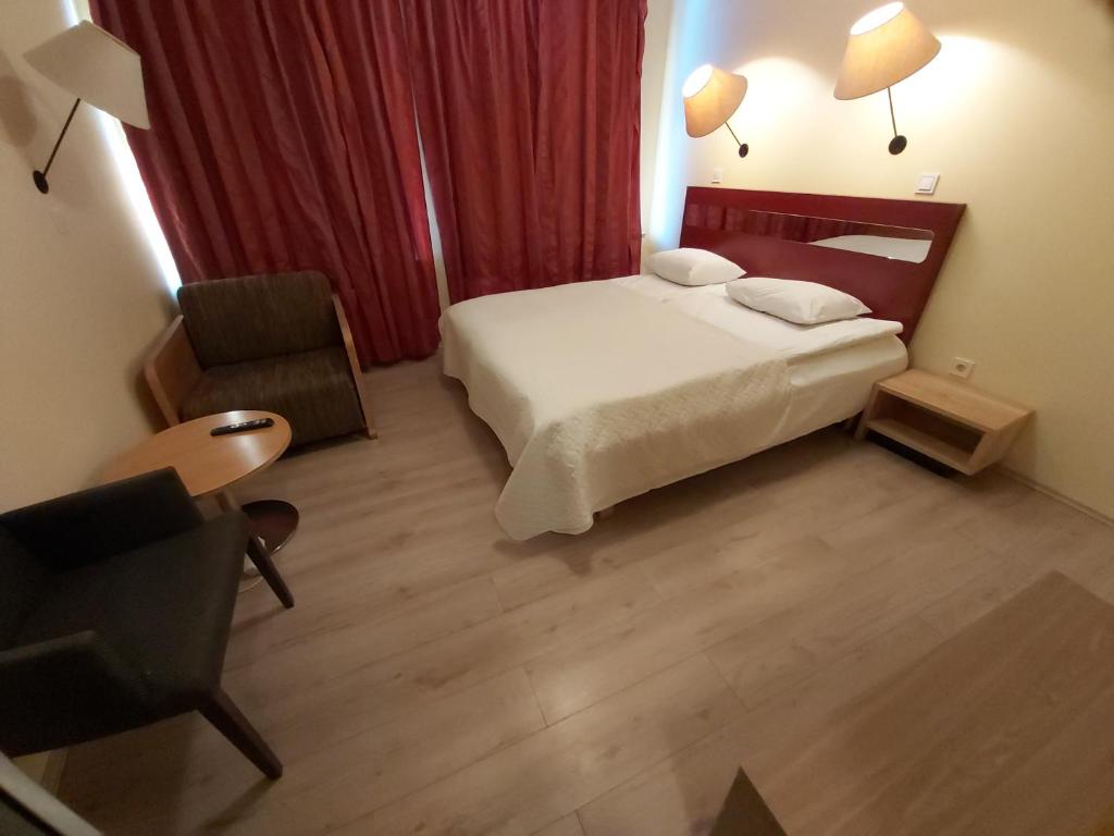 塔林Viva Nord Hostel的配有一张床和一把椅子的酒店客房