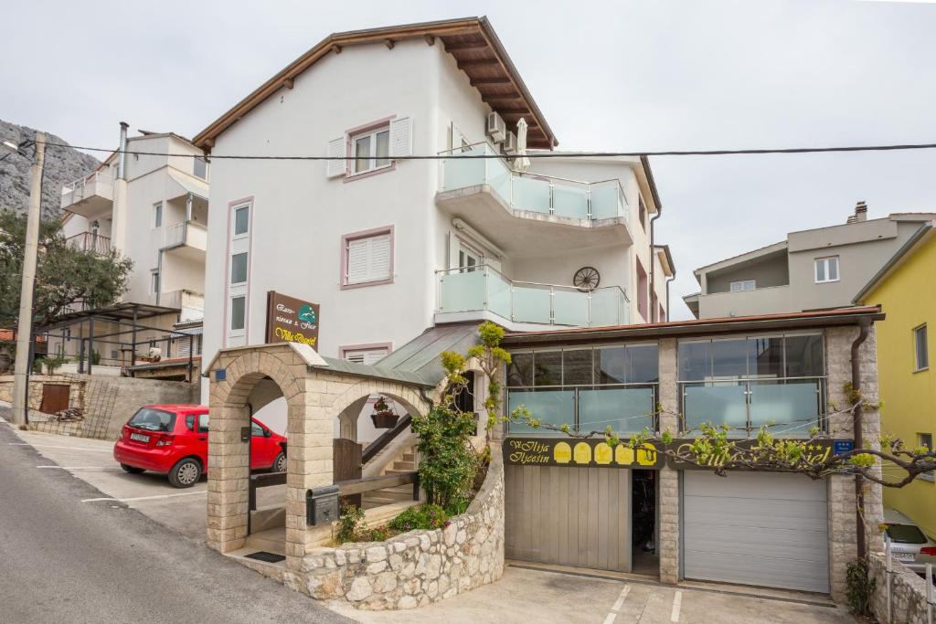 奥米什Apartments and rooms by the sea Nemira, Omis - 2781的前面有车库的建筑