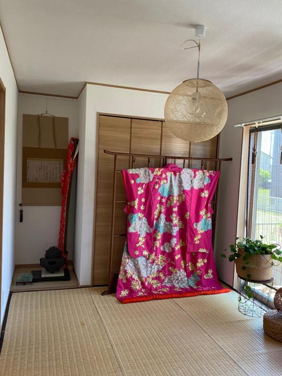 岐阜B&B legare的一张粉红色枕头坐在房间里的床边