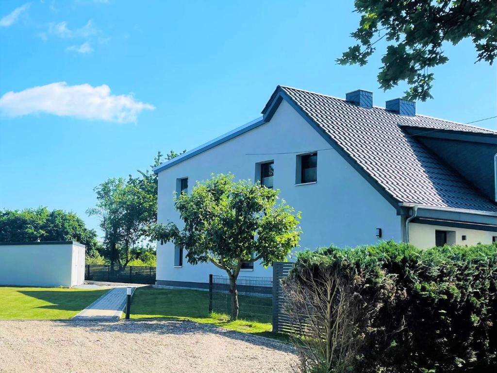 齐罗WILMA holiday home directly at the Baltic Sea的前面有一棵树的白色房子