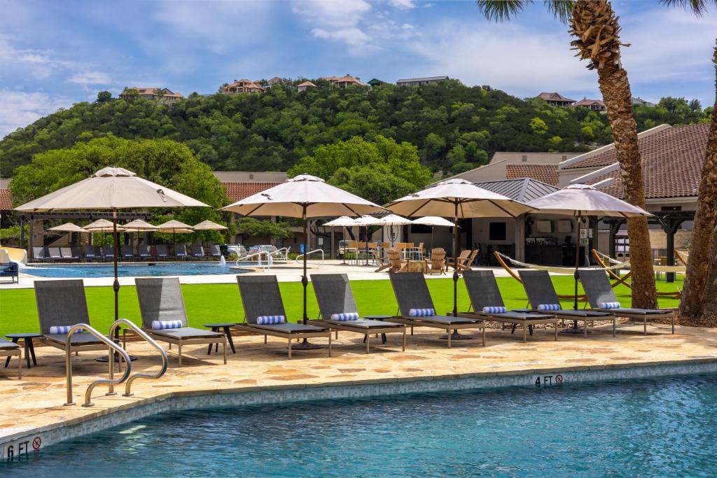 伯尼Tapatio Springs Hill Country Resort的度假村内带躺椅和遮阳伞的游泳池