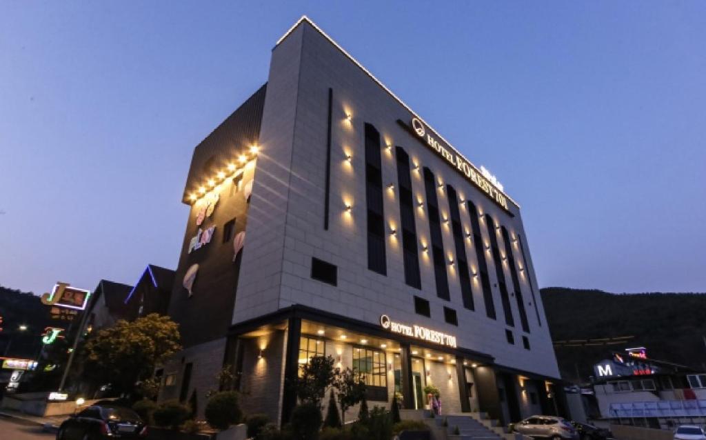 昌原市Forest 701 hotel的一座建筑的侧面有灯