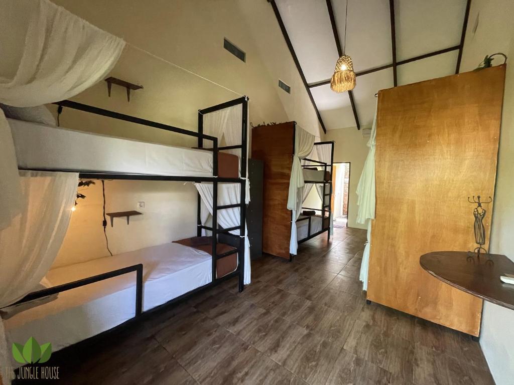 坎古丛林之家旅舍的客房设有三张双层床和盥洗盆。