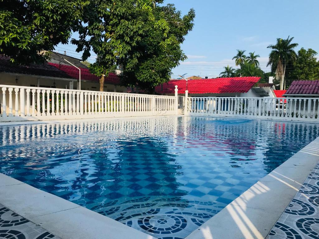 梅尔加GINEZ PRODUCTION COL的一个带白色栅栏的游泳池