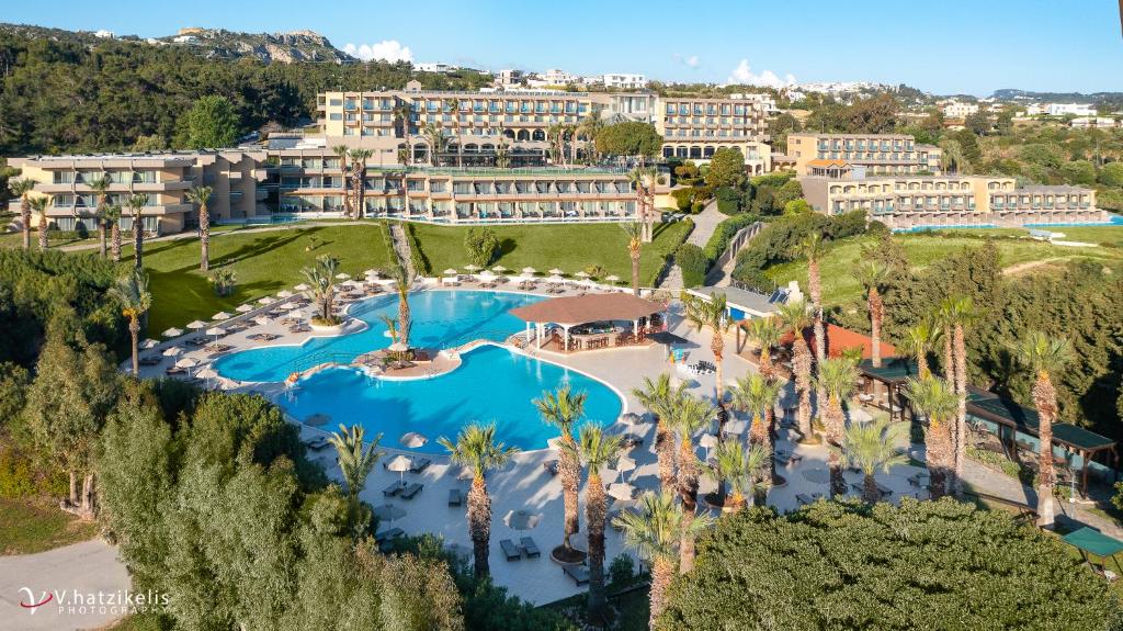 罗德岛卡利地亚Kresten Palace Hotel的享有度假村的空中景致,设有游泳池和棕榈树