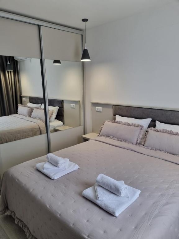 卡赞勒克Dariq的一间卧室,在床上配有两张毛巾和镜子