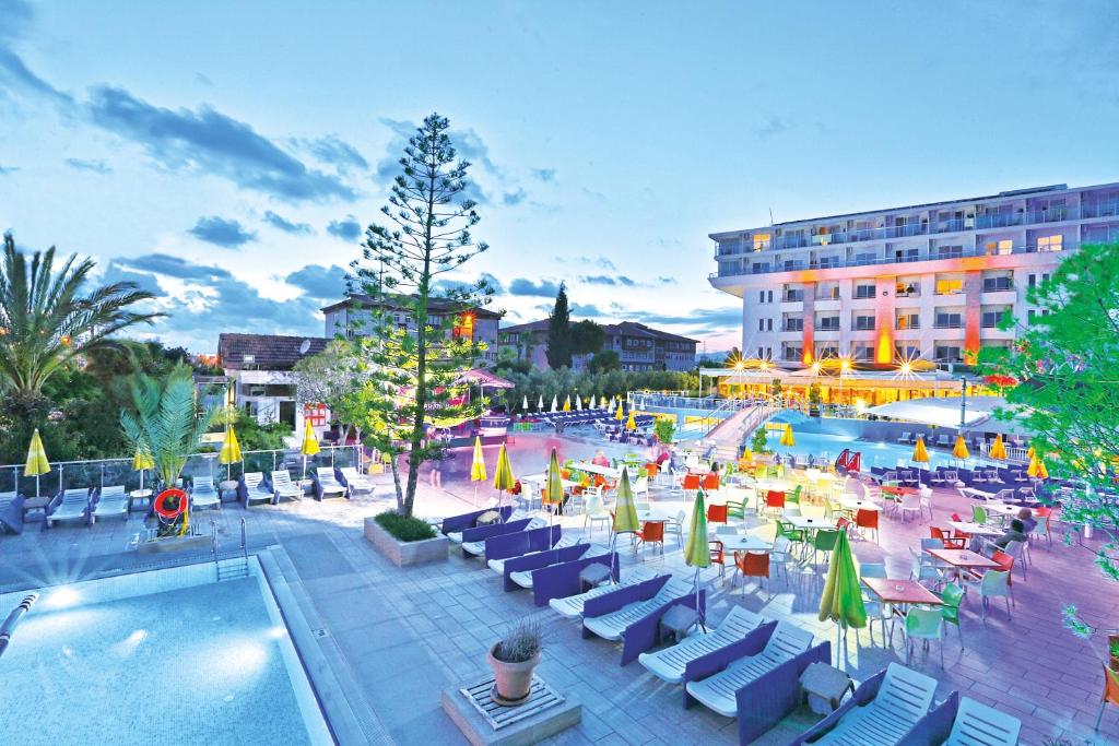 科纳克勒Numa Konaktepe Hotel的一个带游泳池和椅子的度假胜地和一座建筑