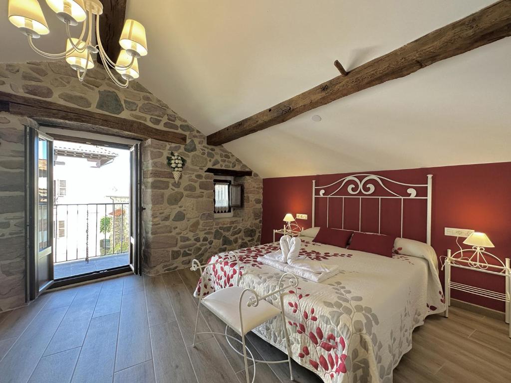 ZigaCasa Rural Sutegia的一间卧室配有一张床、一张桌子和一个窗户。