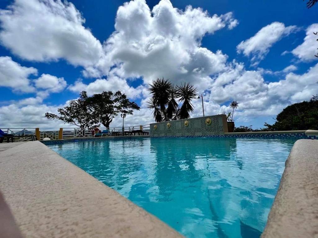 格罗斯岛Kay Nou Apartments的一座拥有蓝天和云的大型游泳池