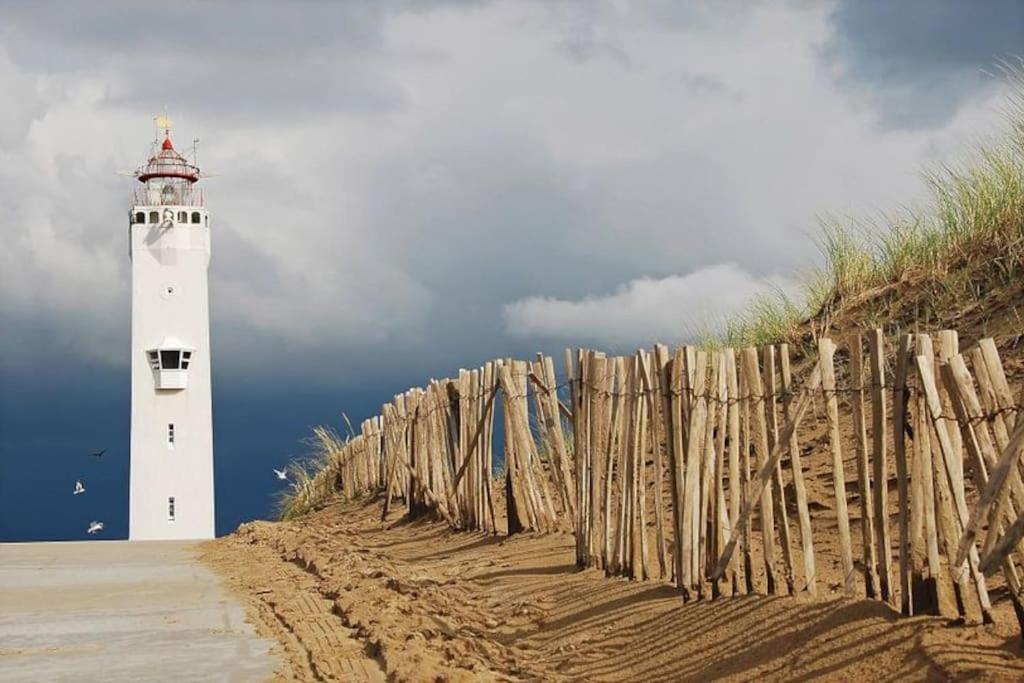 海滨诺德韦克Voilà! - beach at 500m- free parking的海滩上的灯塔,靠近围栏