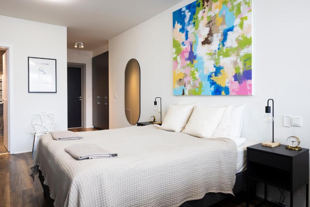雷克雅未克Modern Downtown 1 BR Apartment的卧室配有白色的床和墙上的绘画作品