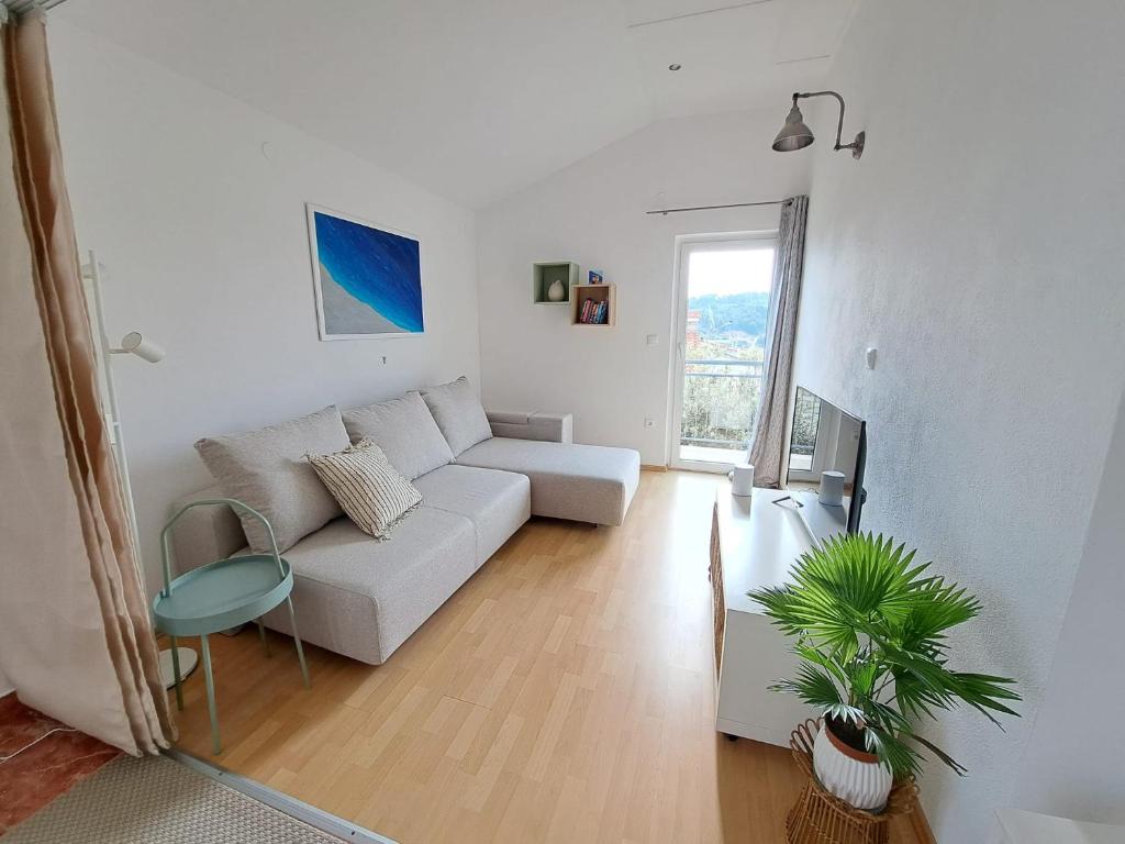 罗加克Villa Porto的一间白色的客厅,配有沙发和植物