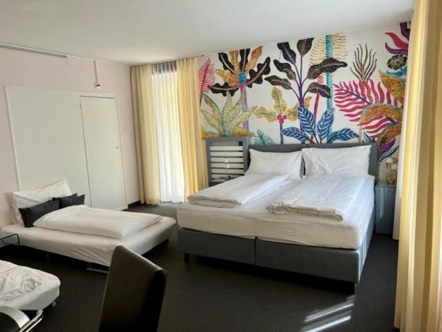 巴塞尔BALEGRA City Hotel Basel Contactless Self Check-in的卧室配有两张床,墙上挂有壁画