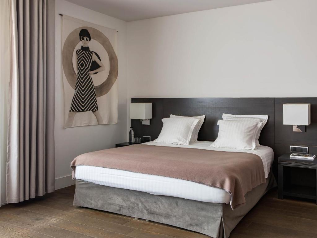 马赛New Hotel of Marseille - Vieux Port的卧室配有一张大床和一幅女画