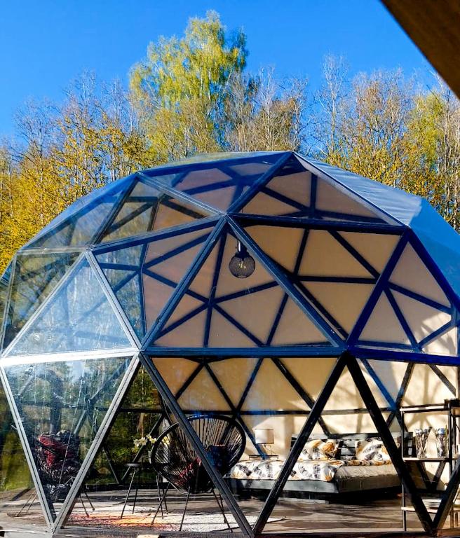 萨拉茨格里瓦Glamping dome tent BUUDA的玻璃圆顶,上面有桌椅