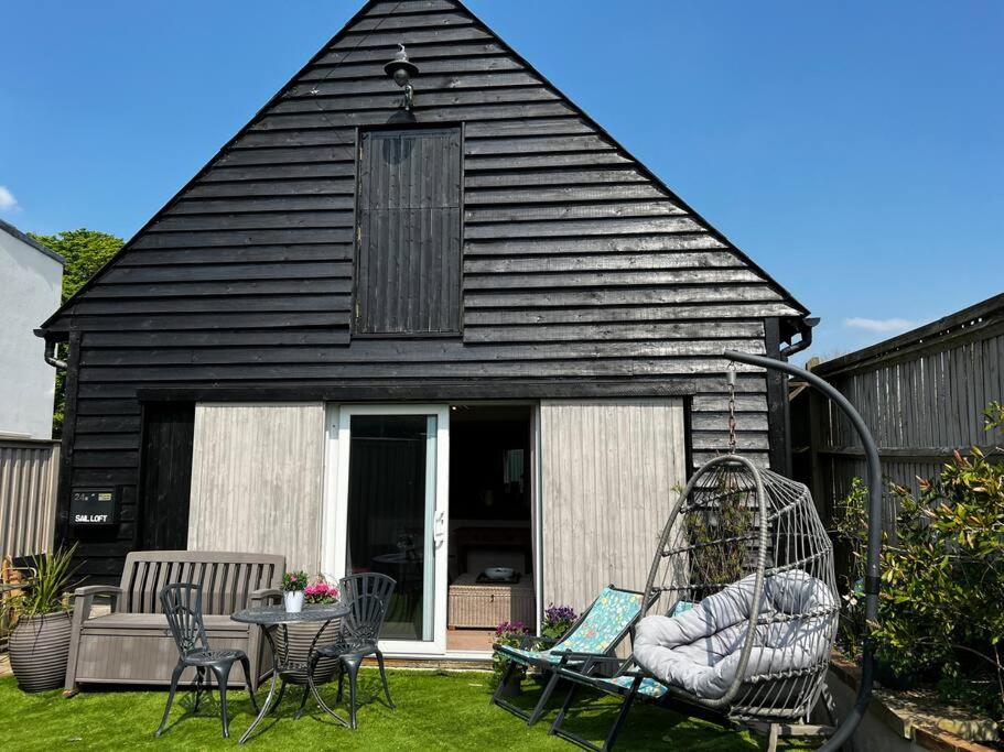 阿伦德尔Quirky 1 bedroom barn on the river in Arundel的院子里有秋千的黑色房子