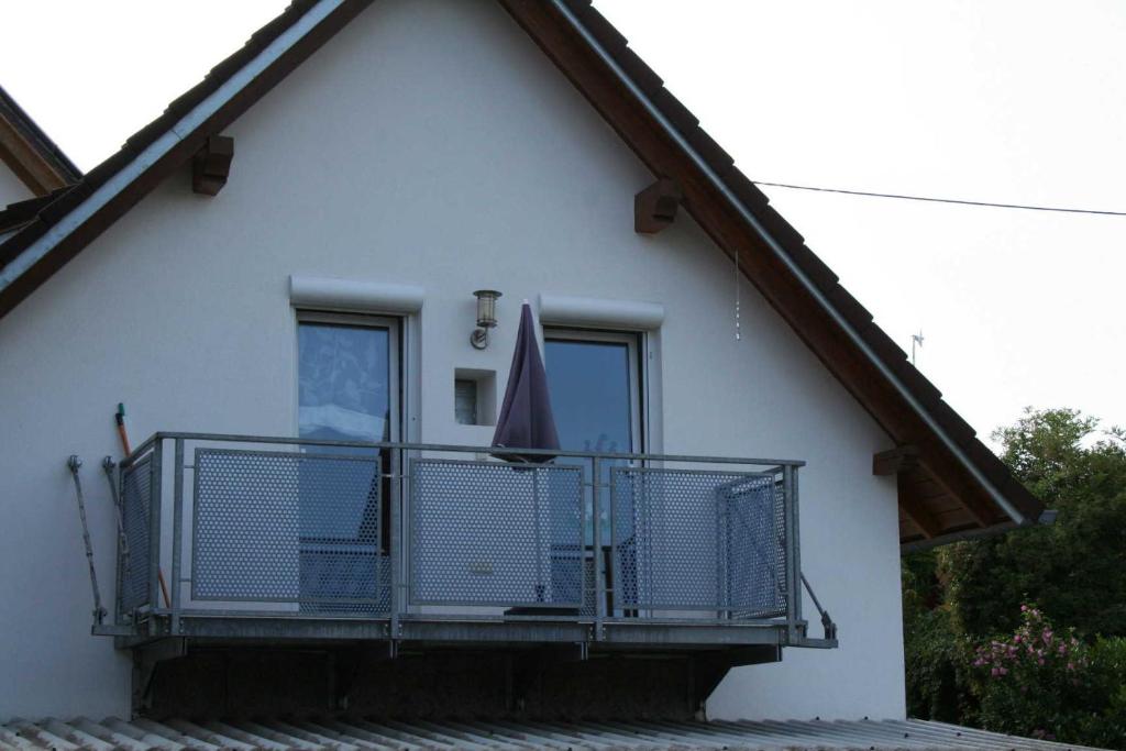 BroggingenBreig,s Ferienwohnung的白色的房子,阳台配有遮阳伞