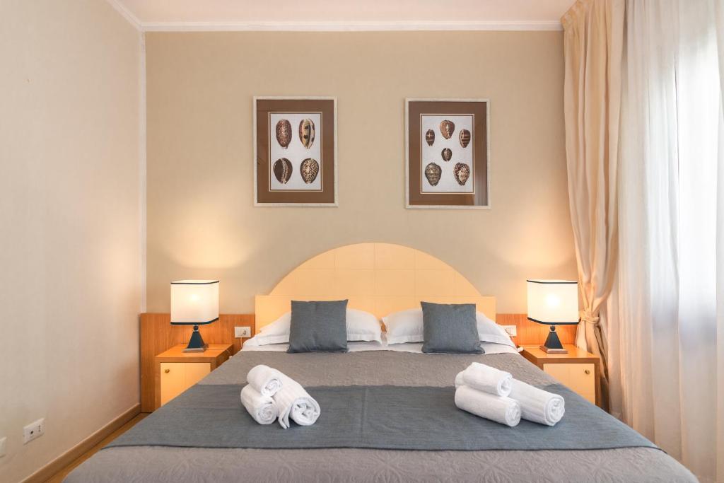 维亚雷焦斯特拉德意大利酒店的一间卧室配有带2条白色毛巾的床
