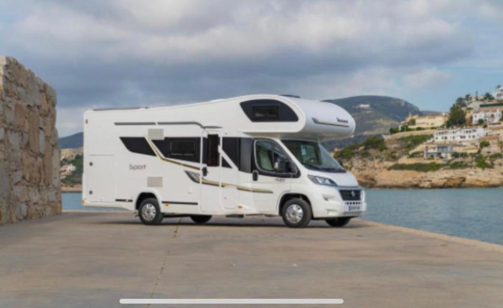 法鲁Portugals Infinity - AutoCaravana Luxo的停在水边的白色露营车