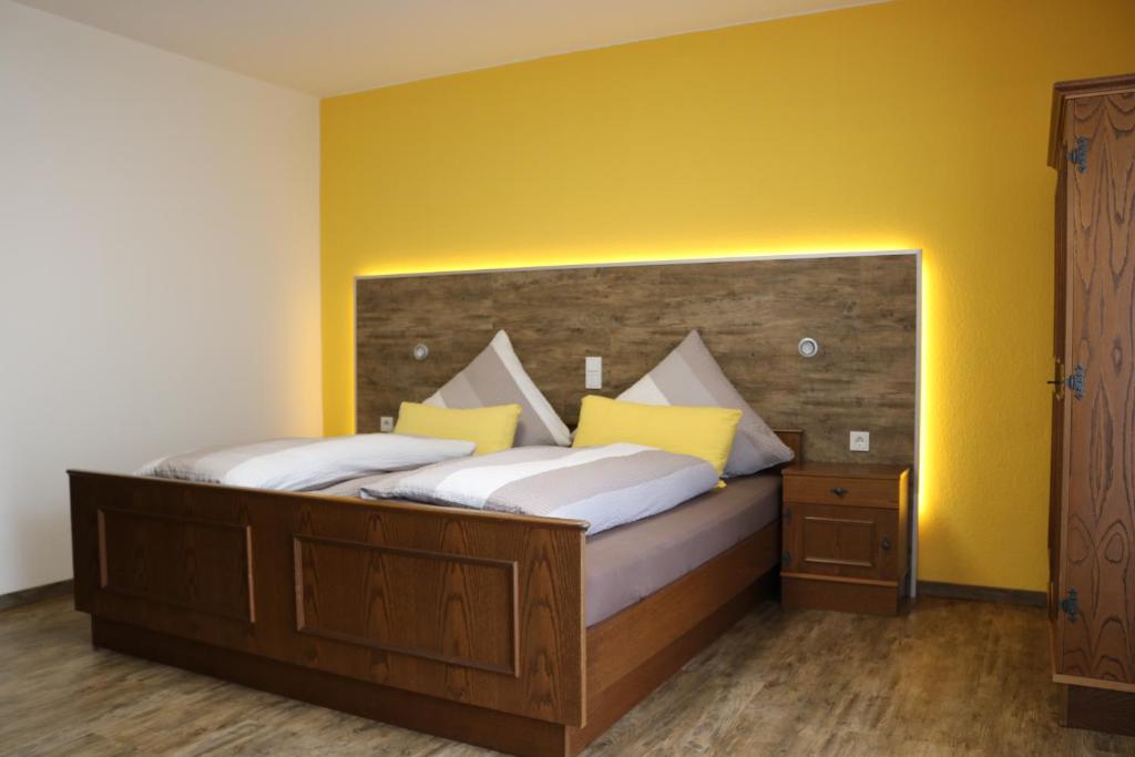 AntrifttalPension Selzer的一间卧室设有一张黄色墙壁的大床
