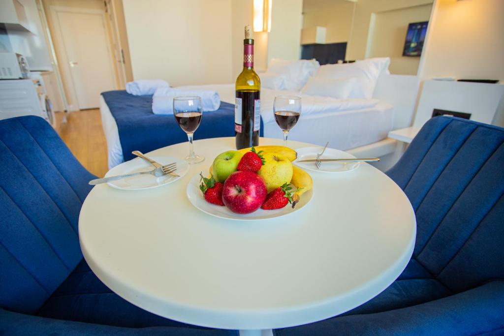 巴统Aparthotel Georgia的一张带一碗水果和酒杯的白桌