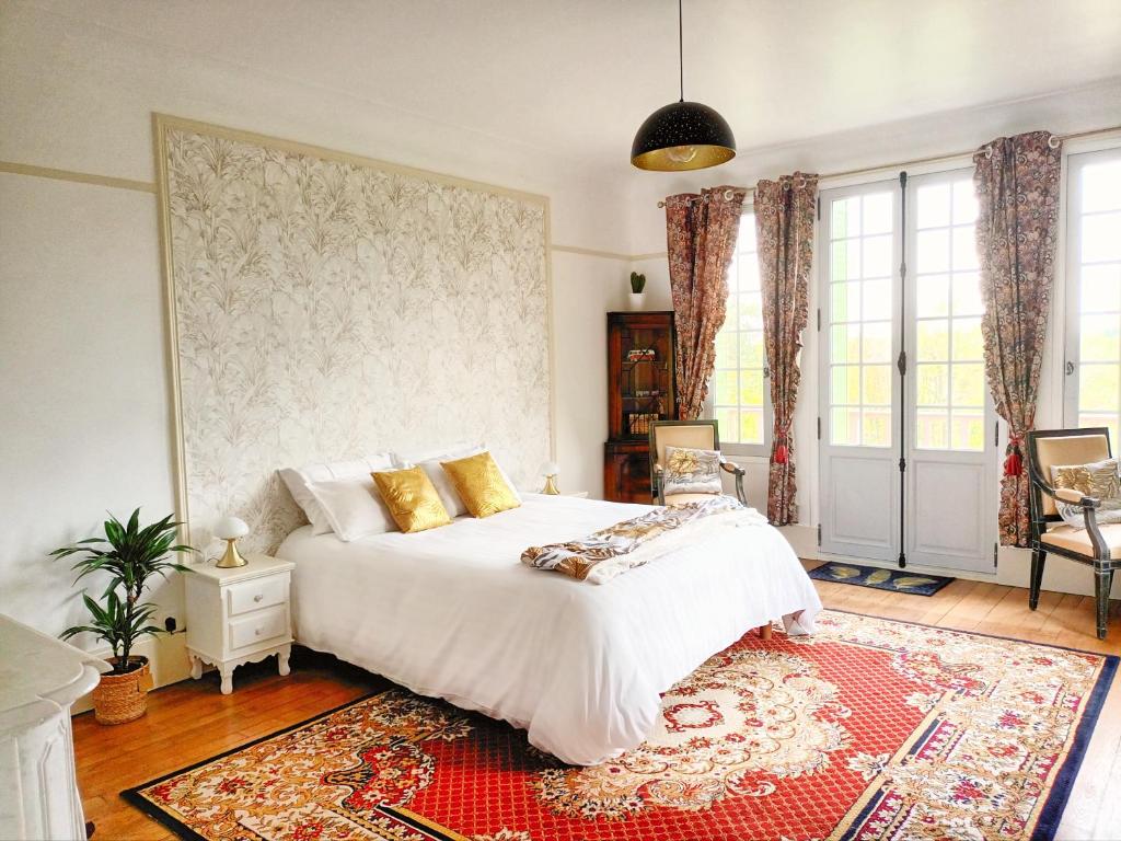 GaillonLe Manoir du Cerf的卧室配有白色的床和红色地毯。