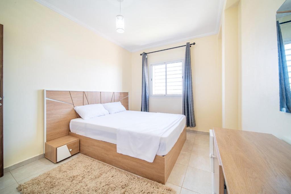 马拉喀什Appartement 2 chambre 5min Aéroport的卧室配有白色的床和窗户。