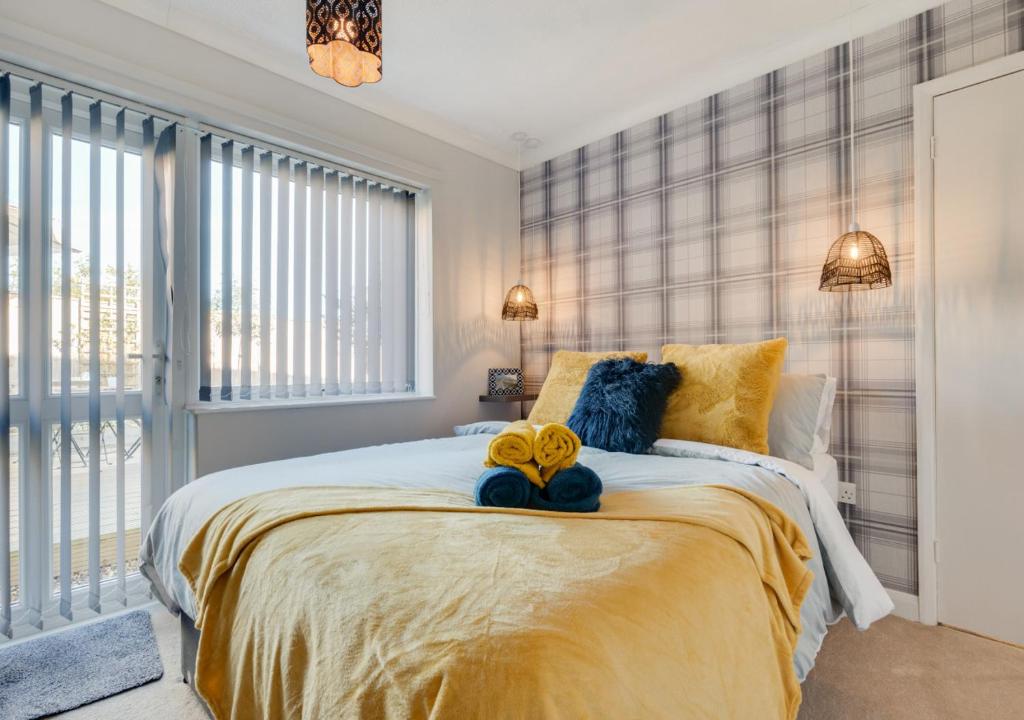 MarthamBrigantine的一间卧室配有一张大床,提供黄色和蓝色的枕头