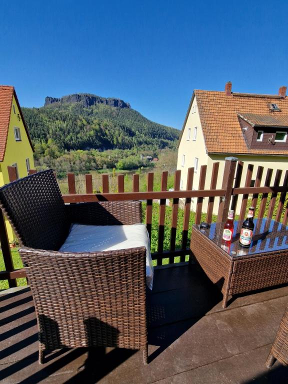 柯尼希施泰因易北Tinyroom mit Ausblick的阳台配有两把椅子和一张桌子,并提供两瓶