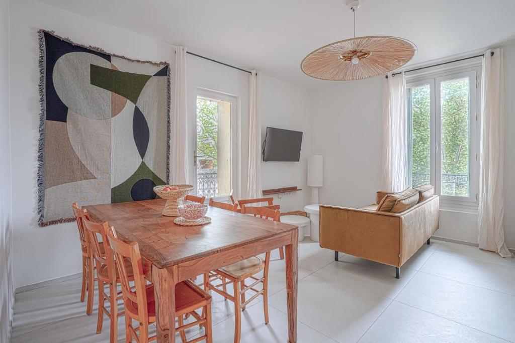 蒙彼利埃NOCNOC - L'Amarelo - Charmant T4 avec terrasse au calme的一间带木桌和椅子的用餐室