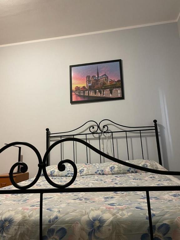 Fara NovareseCentenario affittacamere的卧室内的一张床铺,墙上挂着一幅画