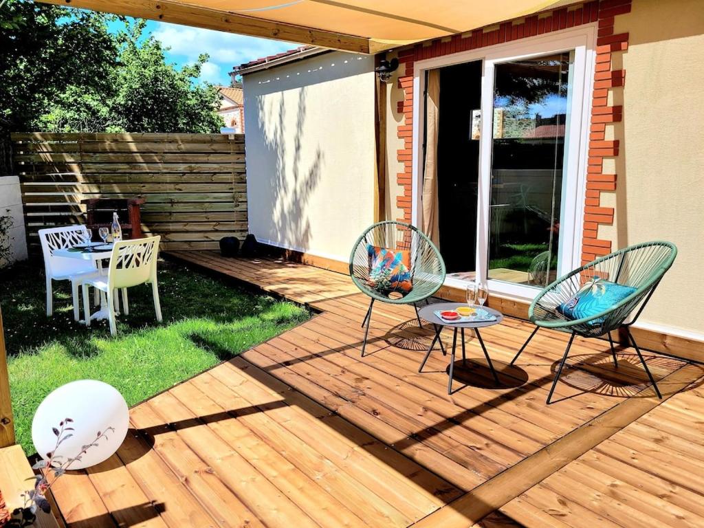 Saint-Aignan-Grand-LieuCopacabana TINY HOUSE studio terrasse jardin的木甲板上配有两把椅子和一张桌子
