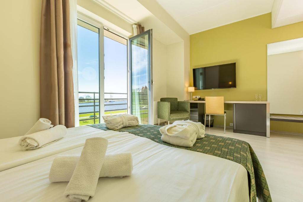 库雷萨雷Meri Seaside Hotel & SPA的一间卧室设有一张大床和大窗户
