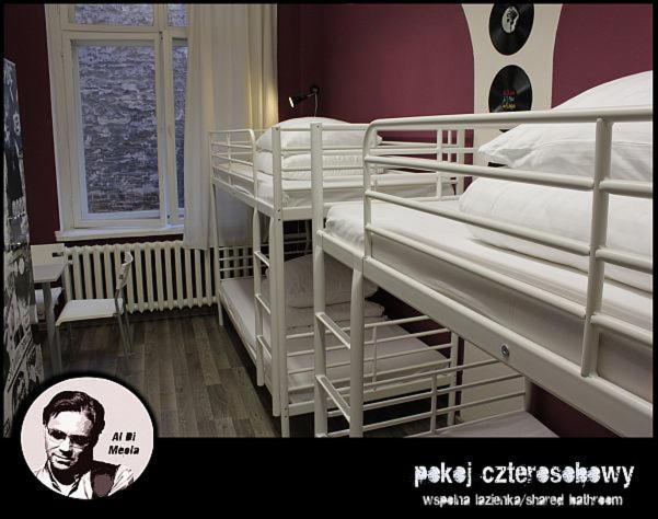 波兹南波兹南拉古塔拉旅馆的一间房间,设有三张双层床,一张男人的照片