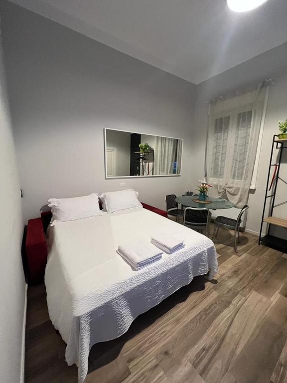 米兰Fiori 3 Apartment的卧室里有一张白色的大床和一张桌子