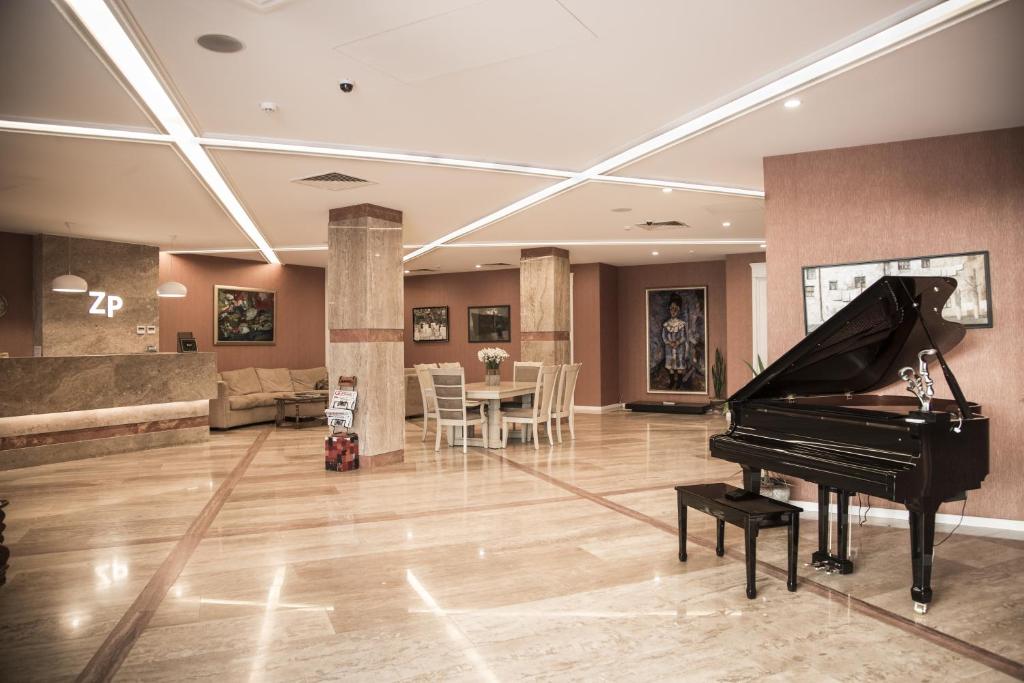 第比利斯ZP宫酒店的一间带钢琴的客厅和一间餐厅