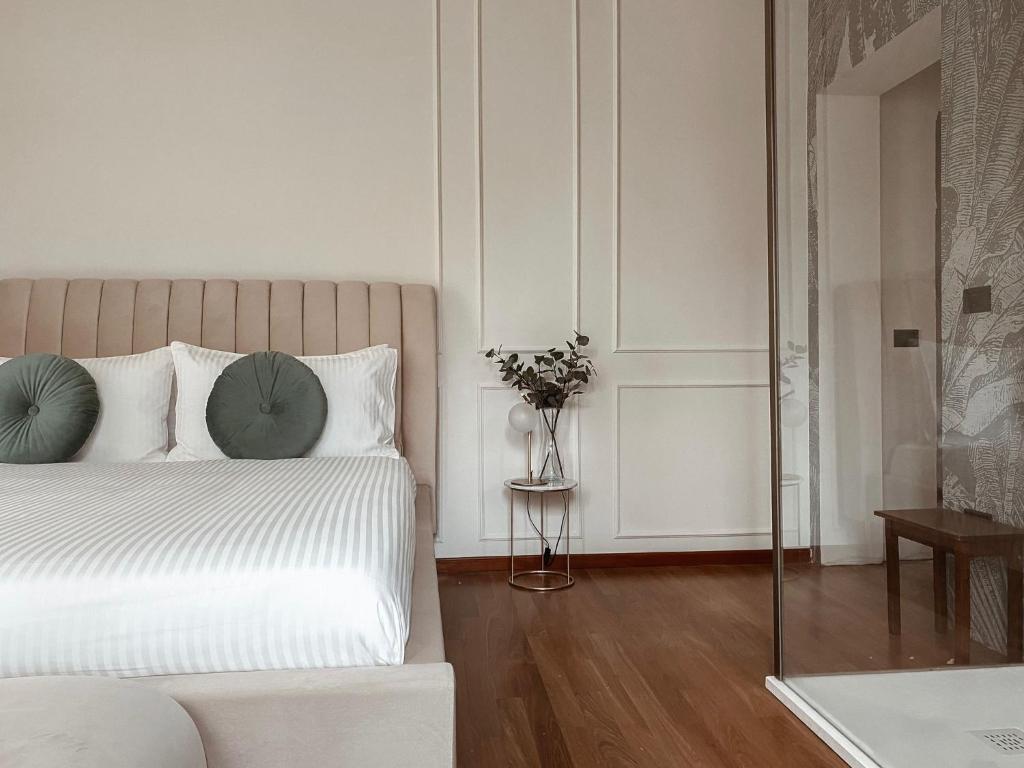 里米尼Villa Maldestra的一间白色的卧室,配有一张床和花瓶
