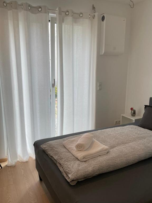 哥根巴赫Black Forest Apartments的卧室配有白色窗帘的床
