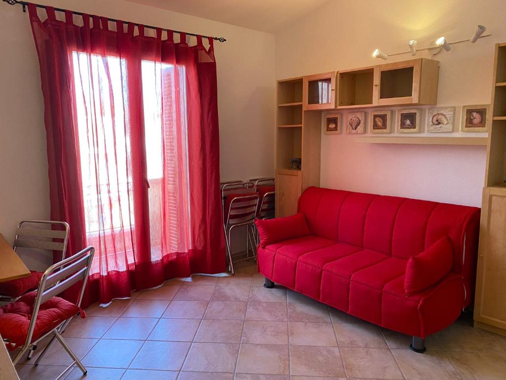 圣特雷莎加卢拉Casa Antonella的客厅配有红色的沙发和桌子