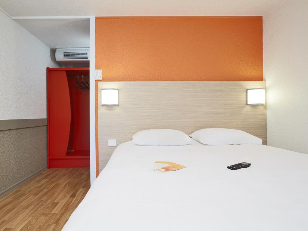 沙斯讷伊迪普瓦图沙斯讷伊未来世界普瑞米尔经典酒店的一间卧室配有一张白色大床和橙色床头板