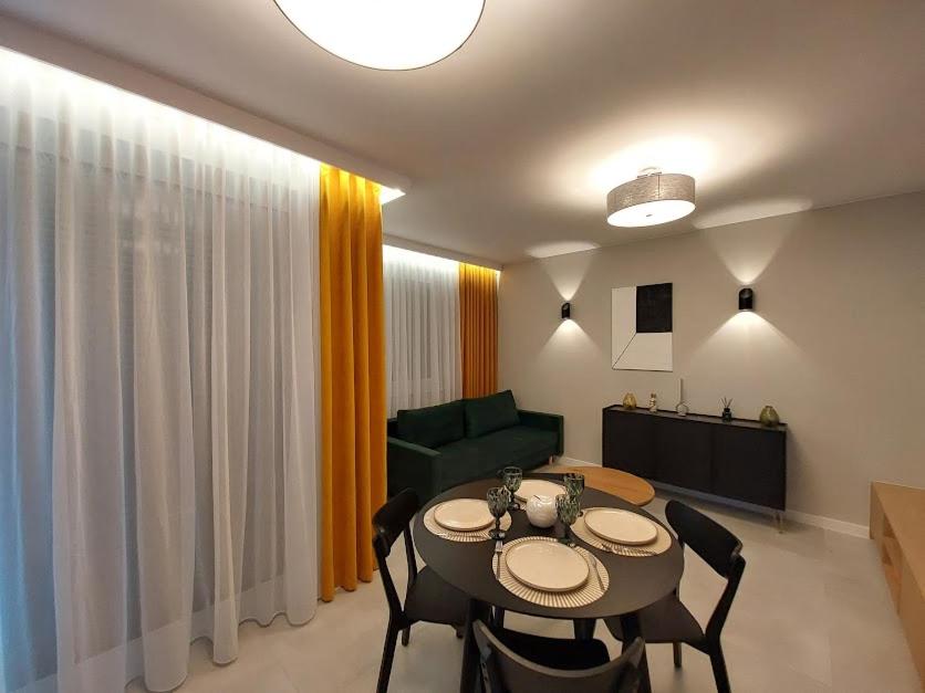 里沃Apartament Olive Rewal z dostępem do basenu的客厅配有桌子和绿色沙发