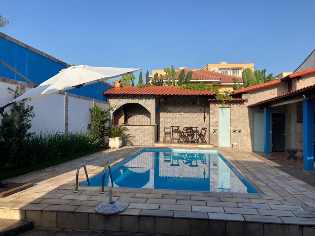 马里卡Casa de Veraneio的房屋前有游泳池的房子