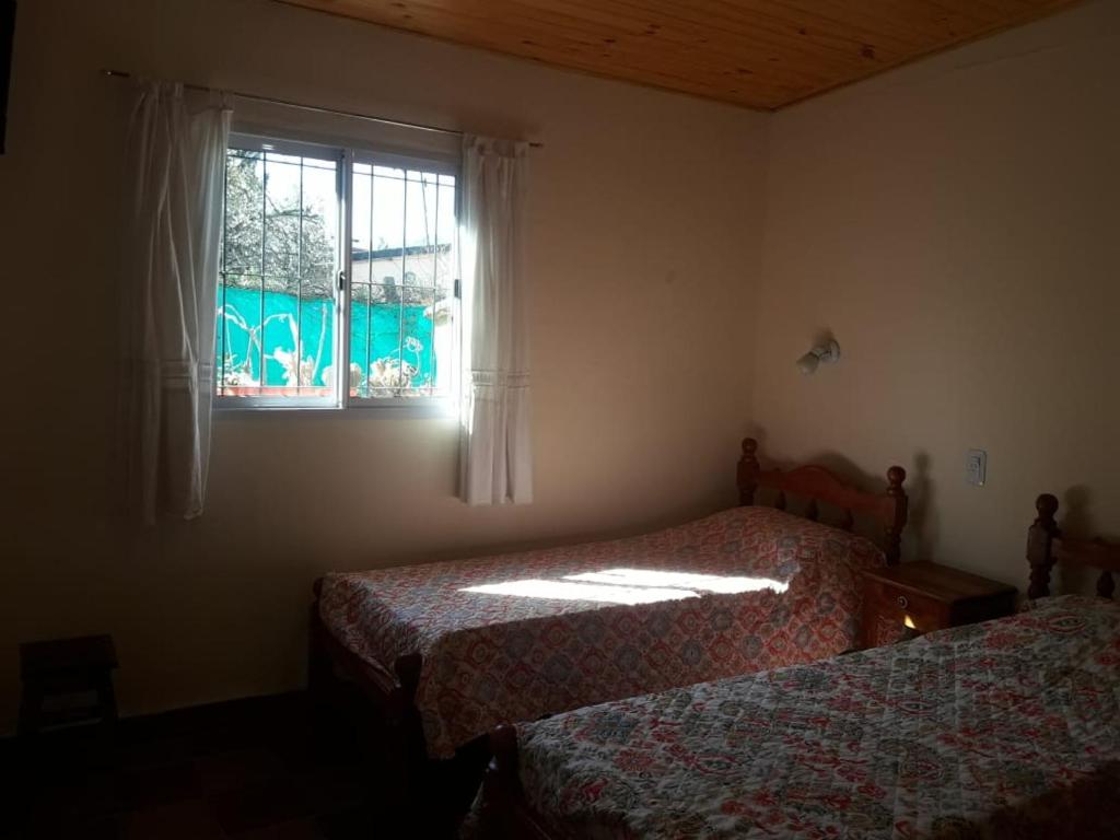 圣萨尔瓦多德朱La Primavera的一间卧室设有两张床和窗户。