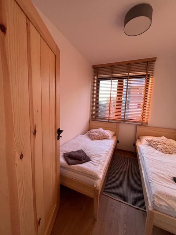 莱斯科Apartament w Dolinie Sanu 2的一间卧室设有两张床和窗户。