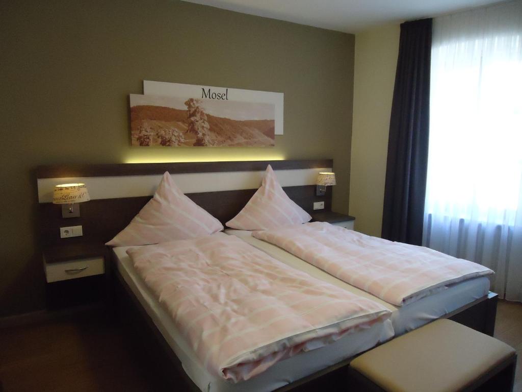 贝尔恩卡斯特尔-库斯湖沃旅馆的一间卧室配有带枕头的床