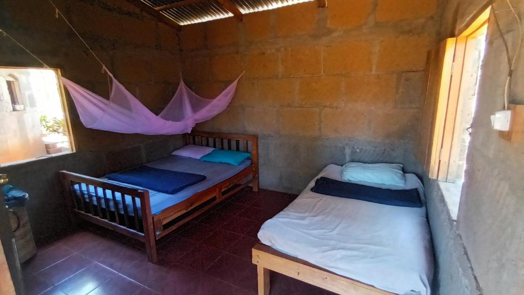 DiriambaFinca Joco Mico的配有粉红色伞的客房内的两张床